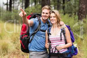 Young happy hiker couple pointing