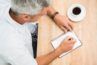 Casual businessman writing on notepad