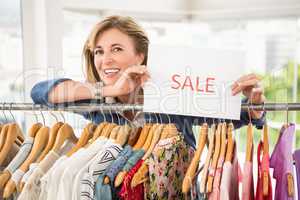 Smiling woman holding sale sign