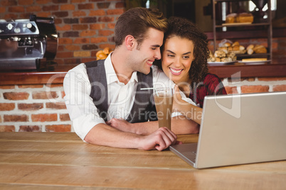 Cute couple on a date watching photos on a laptop