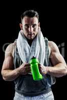 Handsome bodybuilder with towel and bottle