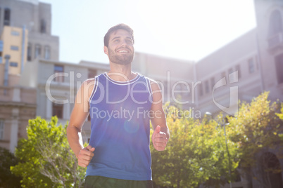 Smiling handsome athlete jogging