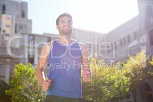 Smiling handsome athlete jogging