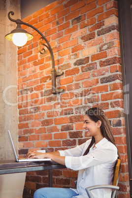 Businesswoman having coffee and working on laptop