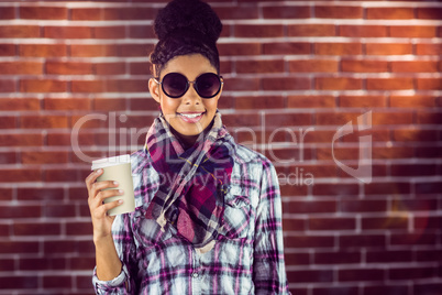 A female hipster holding a cup of coffee