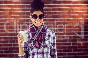 A female hipster holding a cup of coffee