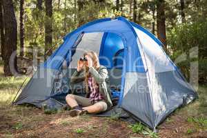 Blonde camper looking through binoculars