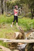 Blonde athlete carrying her mountain bike