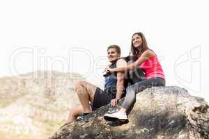 Young happy joggers sitting on rock