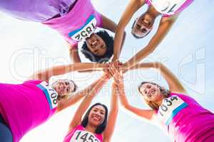 Five smiling runners supporting breast cancer marathon