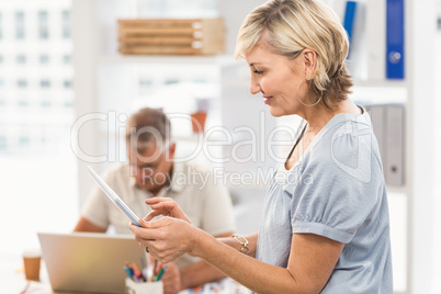 Smiling businesswoman scrolling on a tablet