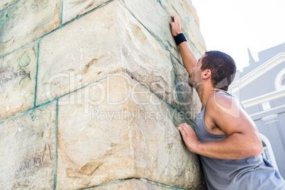 Extreme athlete gripping to wall
