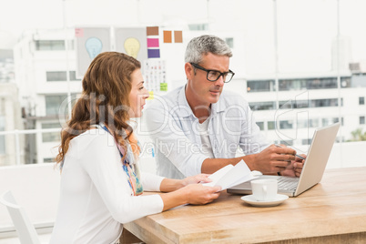 Two casual designers working with laptop