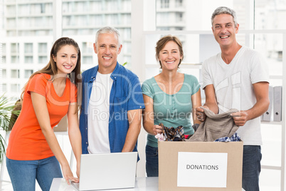 Smiling casual business people with donation box