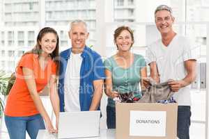 Smiling casual business people with donation box