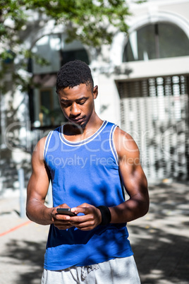 An handsome athlete using his phone