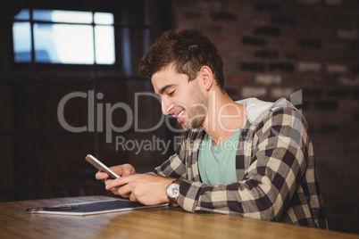 Smiling hipster sitting and texting