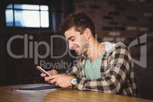 Smiling hipster sitting and texting