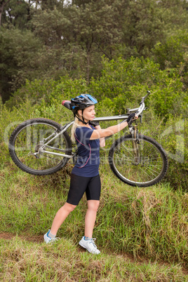 Athletic blonde carrying her mountain bike