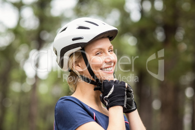 Young pretty happy biker taking off helmet