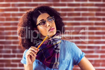 Daydreaming attractive hipster holding pen