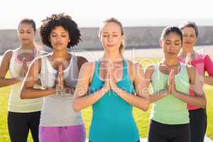 Peaceful sporty women doing prayer position