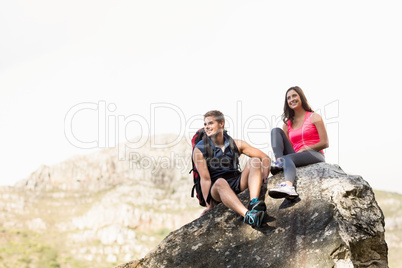 Young happy joggers sitting on rock