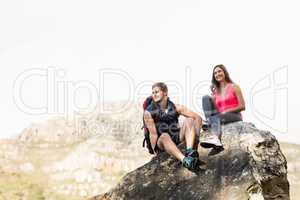 Young happy joggers sitting on rock
