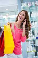Pretty woman talking on phone while shopping