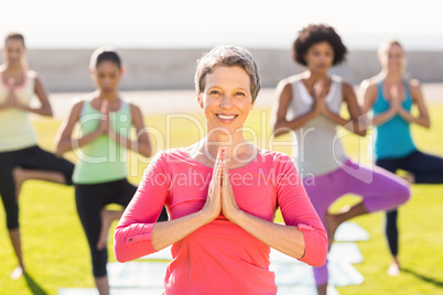 Smiling sporty woman doing yoga in yoga class