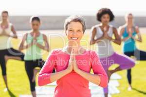 Smiling sporty woman doing yoga in yoga class