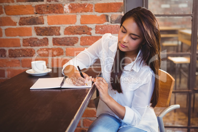 Smiling businesswoman having coffee and planning her week