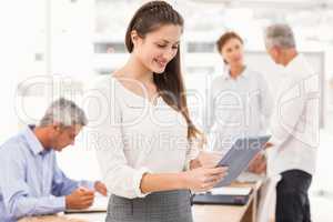 Smiling businesswoman using tablet in a meeting