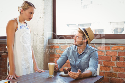 Handsome hipster talking to blonde waitress