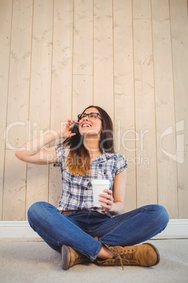 Pretty hipster on the phone holding cup