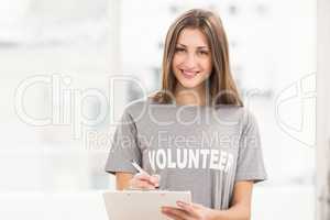 Smiling brunette volunteer with clipboard