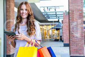 Pretty woman shopping at the mall using tablet