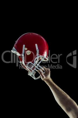 American football player holding up his helmet