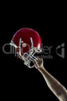 American football player holding up his helmet