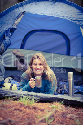 Portrait of a young pretty hiker lying in a tent