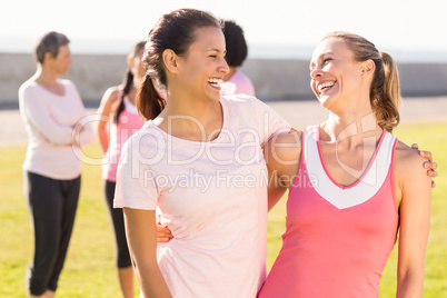 Two smiling women wearing pink for breast cancer