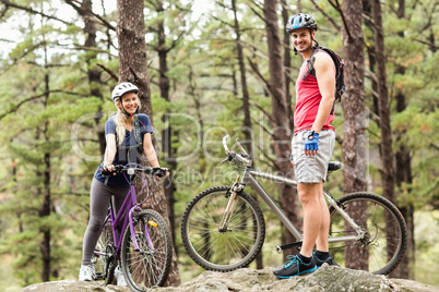 Young happy couple on bikes looking at camera