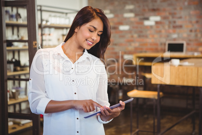 Smiling young businesswoman holding a tablet