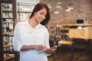 Smiling young businesswoman holding a tablet