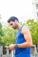 Handsome athlete using smartphone