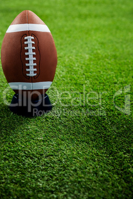 American football standing on holder