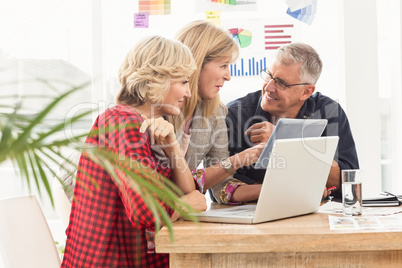 Smiling business team discussing over a tablet