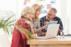 Smiling business team discussing over a tablet