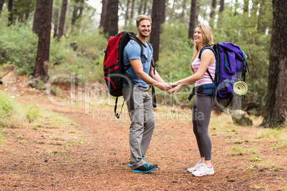 Young happy hiker couple holding hands