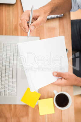 Hands holding notepad over wooden desk